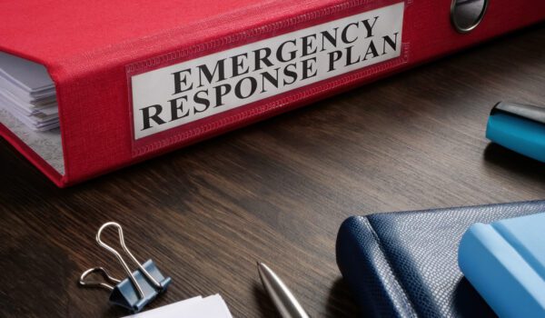 Red folder labeled Emergency Response Plan on a desk..